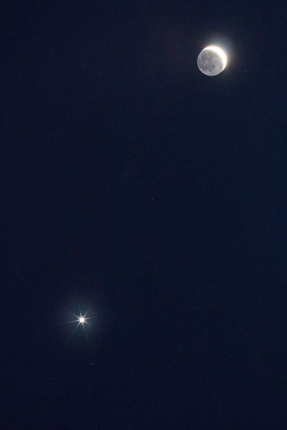 The moon and planet Venus in the night sky.