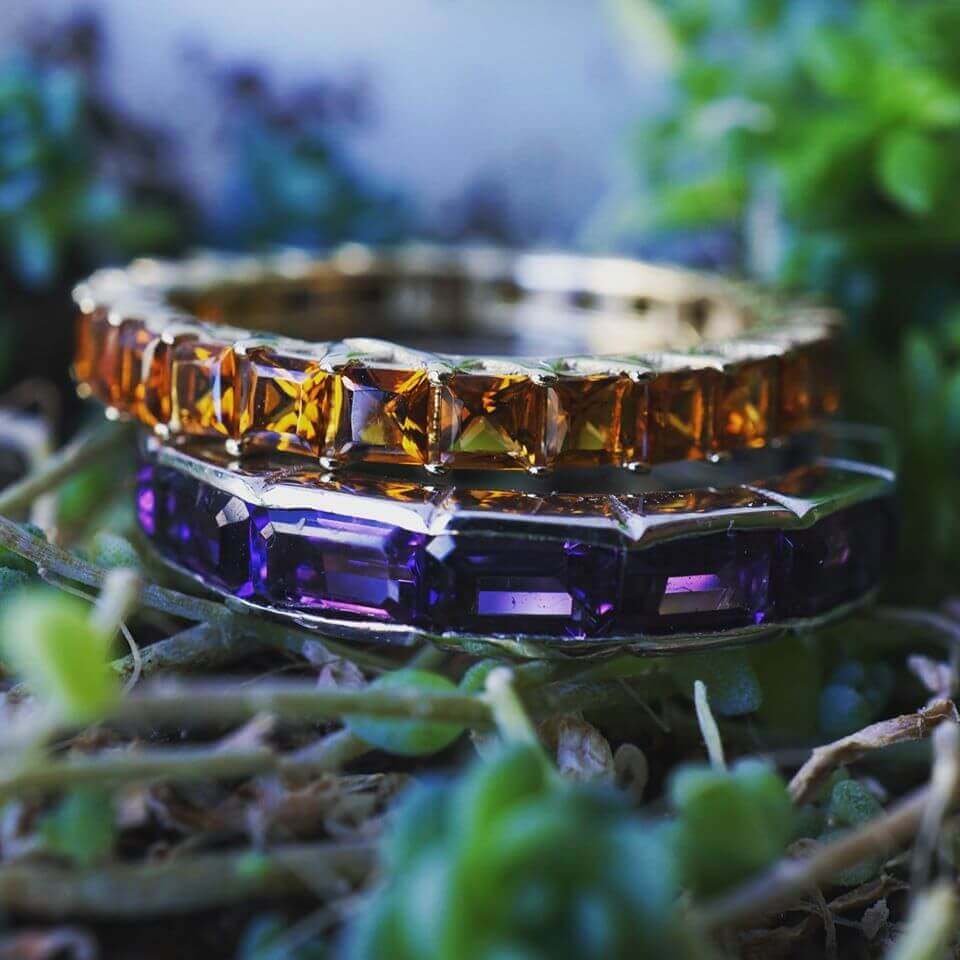 An amethyst eternity ring and a citrine eternity ring