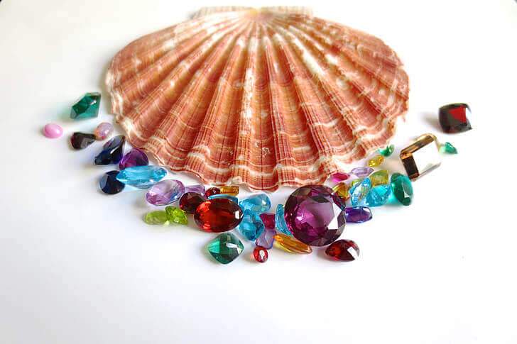 colorful gems arranged in front of a seashell