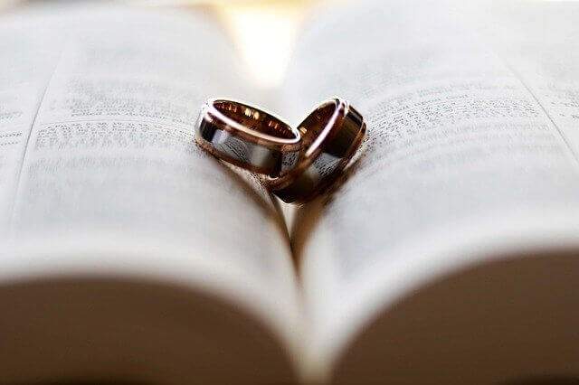 wedding bands resting on an open book